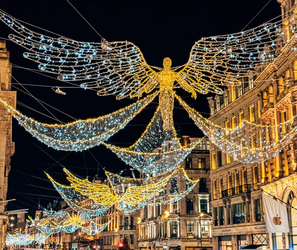 Illuminated angel decorations with golden wings lighting up Regent Street at Christmas.